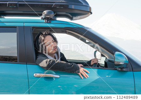 一名30多歲的男子正在開車 112489489