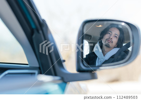 一名30多歲的男子正在開車 112489503