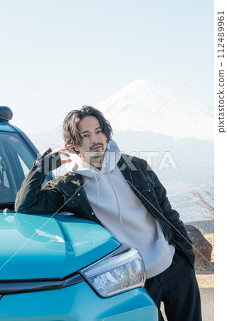 A man in his 30s taking a commemorative photo with his car in the parking lot while driving A man in his 30s taking a commemorative photo with his car in the parking lot while driving 112489961