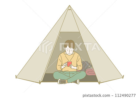 一個穿著長袖長褲的男孩盤腿坐在帳篷門口,放鬆地看著紅色的智慧型手機螢幕。 一個穿著長袖長褲的男孩盤腿坐在帳篷門口,放鬆地看著紅色的智慧型手機螢幕。 112490277