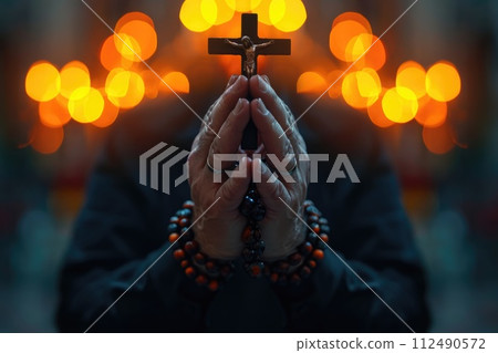 Soulful prayer: a man in quiet devotion, hands clasped around a rosary cross, seeking solace and spiritual connection, capturing the essence of serene contemplation, faith, and religious devotion. 112490572