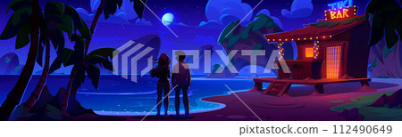 Couple near tiki bar on shore of tropical lagoon 112490649