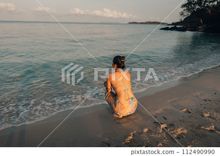 Woman walking on the beach in the morning 112490990