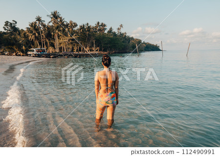Woman walking on the beach in the morning 112490991