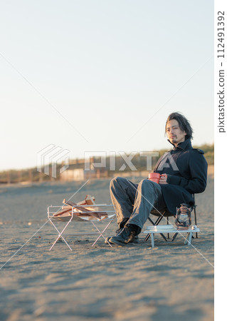 一名30多歲的男子在海灘生下篝火 112491392