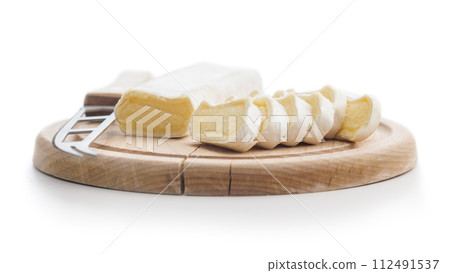 Whole and sliced cheese on wooden board 112491537