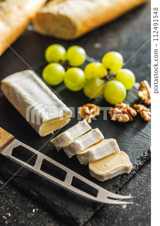 Close-up of cheese and grapes on slate 112491548