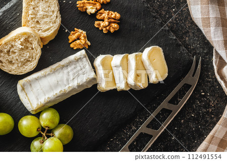 Close-up of cheese and grapes on slate 112491554