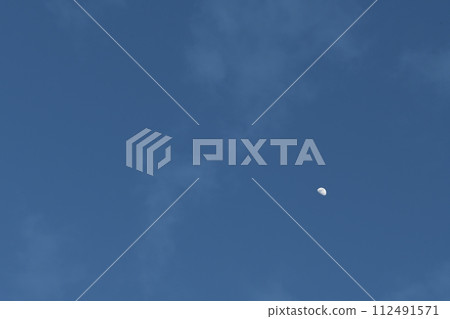 Moon age 8.2, the waxing moon shines in the sky as dusk approaches. 112491571