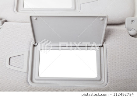 Sun visor with a mirror made of light gray plastic on a white background in a photo studio. Spare part of the car interior for replacement in a car service or for sale on auto dismantling. Sun visor with a mirror made of light gray plastic on a white background in a photo studio. Spare part of the car interior for replacement in a car service or for sale on auto dismantling. 112492784