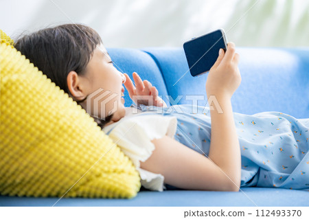 Girl watching videos on her smartphone 112493370