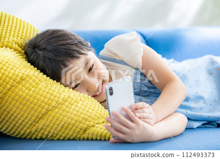 Elementary school student looking at smartphone 112493373