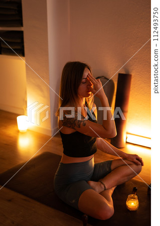 Meditation and breathing during yoga classes. The girl holds her fingers on her forehead and breathes. Meditation and breathing during yoga classes. The girl holds her fingers on her forehead and breathes. 112493750