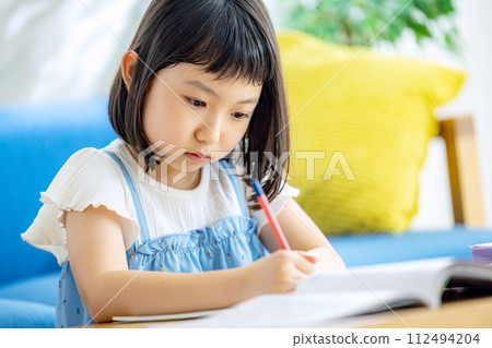 小學女孩在客廳裡學習 112494204