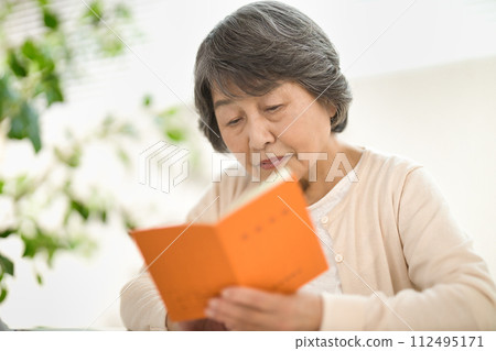 一位老年婦女一邊使用電腦，一邊查看她的退休金筆記型電腦 — 生命的終結 112495171