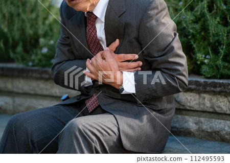 Senior man suit heart attack sitting 112495593