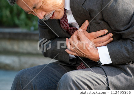 Senior man suit heart attack sitting 112495596