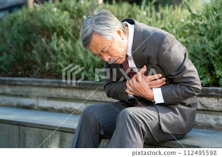 Senior man suit heart attack sitting 112495598