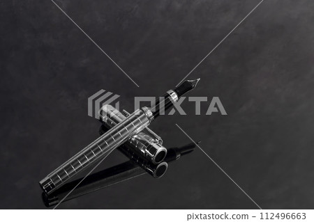 Fountain pen on marble and gray background with reflection. Vibration focus. 112496663