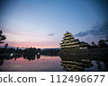 Matsumoto Castle at dawn and the sunrise reflected on the moat 112496677
