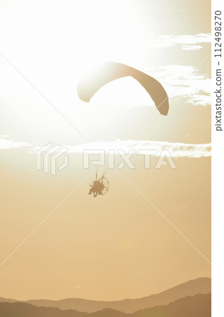 機動滑翔傘在黃昏時起飛至天空 機動滑翔傘在黃昏時起飛至天空 112498270