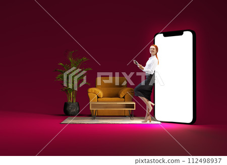 Woman in business clothes leaning on giant 3D model smartphone with armchair and plant beside her. Developing online app Woman in business clothes leaning on giant 3D model smartphone with armchair and plant beside her. Developing online app 112498937