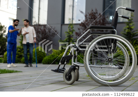 Doctor and patient having a talk in a hospital yard 112499622