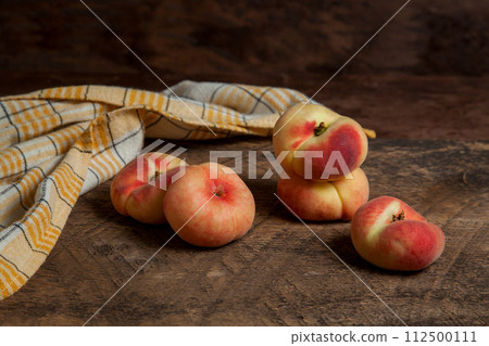 Several saturn peaches or flat peaches on wooden background.. Several saturn peaches or flat peaches on wooden background.. 112500111