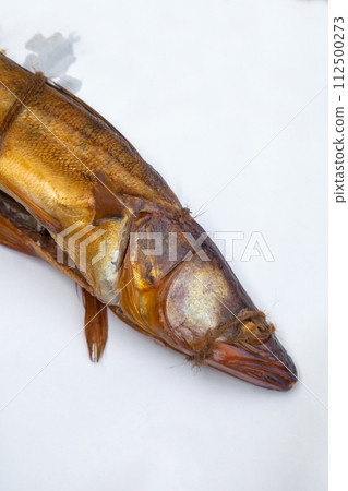 Smoked freshwater zander fish for home use on white paper.. Smoked freshwater zander fish for home use on white paper.. 112500273