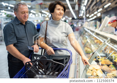Couple of spouses buy ready-made meals in culinary department 112500374