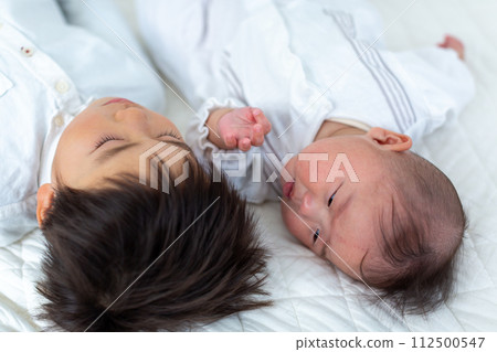 Two infants and an infant taking a nap 112500547