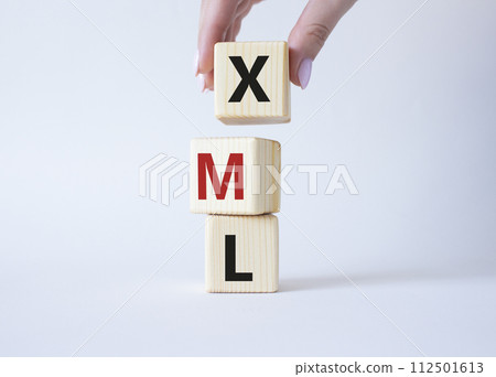 XML - Extensible Markup Language. Wooden cubes with word XML. Businessman hand. Beautiful white background. Business and Extensible Markup Language concept. Copy space. 112501613