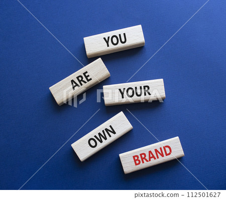 You are your own brand symbol. Wooden blocks with words You are your own brand. Beautiful deep blue background. Business and You are your own brand concept. Copy space. 112501627