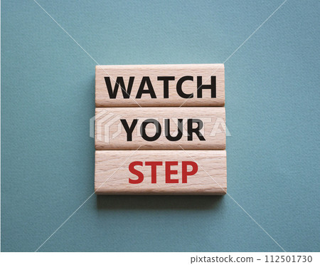 Watch your Step symbol. Concept words Watch your Step on wooden blocks. Beautiful grey green background. Business and Watch your Step concept. Copy space. 112501730