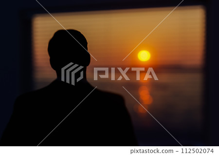 A man looks out the window 112502074