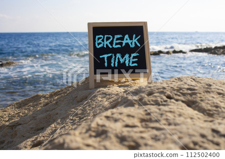 Break Time symbol. Break Time black chalk blackboard. Beautiful sea background. Business and Break Time concept. Copy space. Break Time symbol. Break Time black chalk blackboard. Beautiful sea background. Business and Break Time concept. Copy space. 112502400