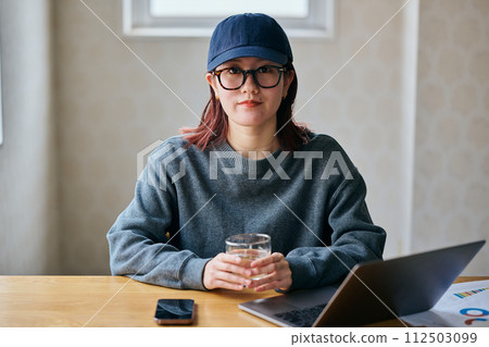 年輕女子拿著眼鏡看著相機 112503099