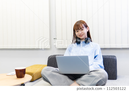 A woman working on a laptop/working remotely 112503122