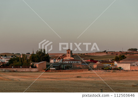 Rural landscape with church spire on horizon amidst trees and small village Rural landscape with church spire on horizon amidst trees and small village 112503646