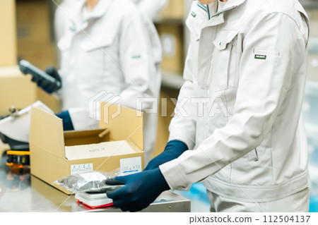 Young worker labeling in the backyard, faceless 112504137