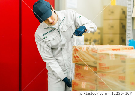 一名年輕工人在發貨前包裝產品 112504167