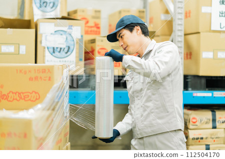A young worker wrapping the product before shipping 112504170