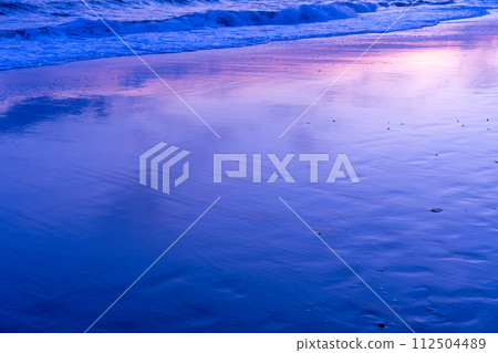 反射著日落的海灘上的神奇時刻 112504489