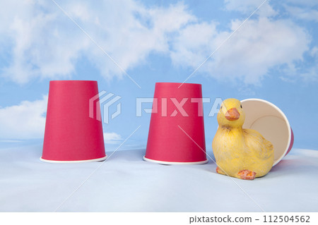 Three paper cups are used to play the game of bonneteau and a duck under one cup Three paper cups are used to play the game of bonneteau and a duck under one cup 112504562