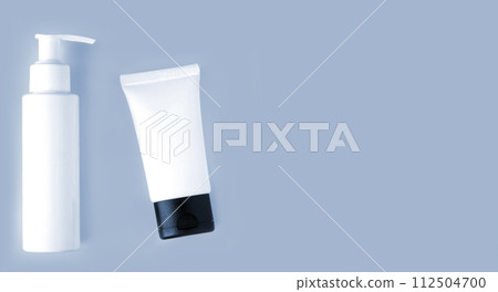 White bottle and tube of cosmetic products background 112504700