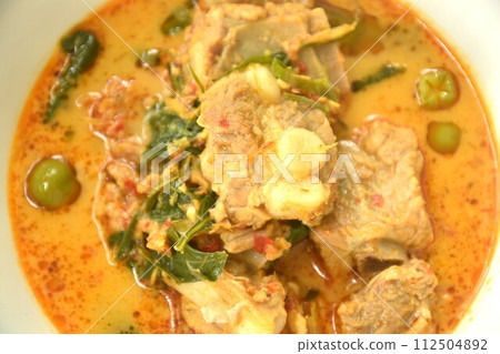 boiled pork bone with basil and chili in coconut milk curry soup on bowl 112504892