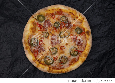 pizza spicy chorizo with jalapeno peppers close-up on a black backgroundtop view.  112505577