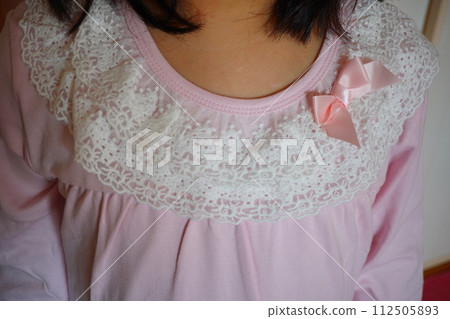 四年級女生睡衣的領口。可愛的蕾絲和絲帶。 四年級女生睡衣的領口。可愛的蕾絲和絲帶。 112505893
