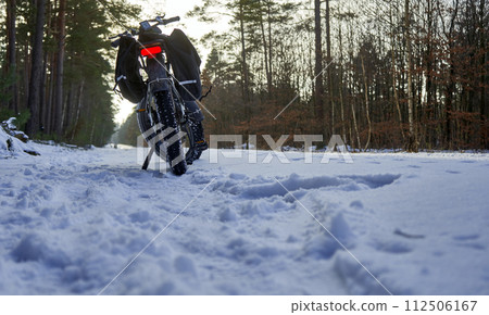 Rear View of an Electric Fat Bike on a Snow-Covered Forest Path, Bicycle Tour Germany Rear View of an Electric Fat Bike on a Snow-Covered Forest Path, Bicycle Tour Germany 112506167