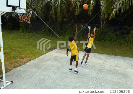 Black men in sportswear playing streetball Black men in sportswear playing streetball 112506208